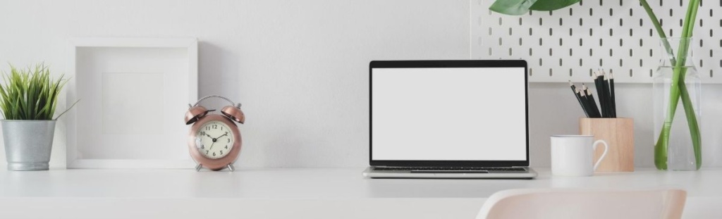 Desk with laptop and clock